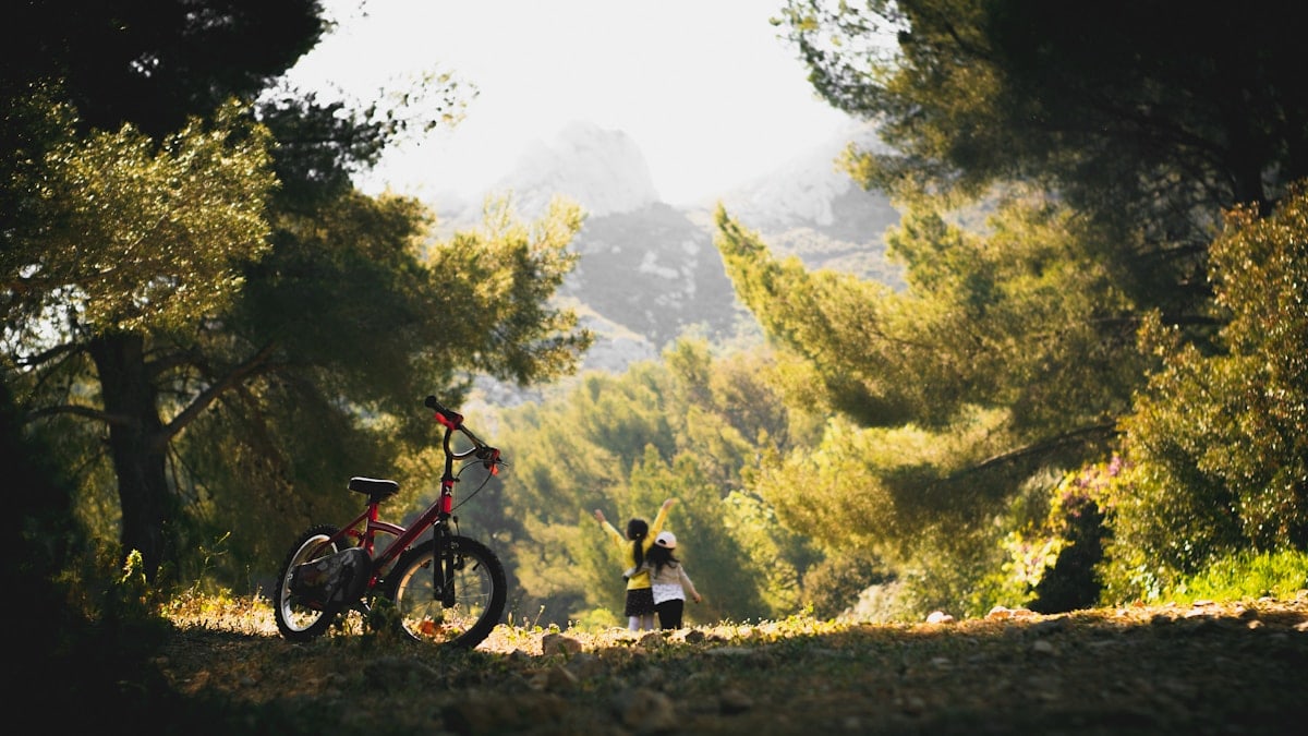 man and woman riding on red and black mountain bike during daytime